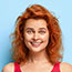 pretty lady with curly red hair in a pretty red vest smiling